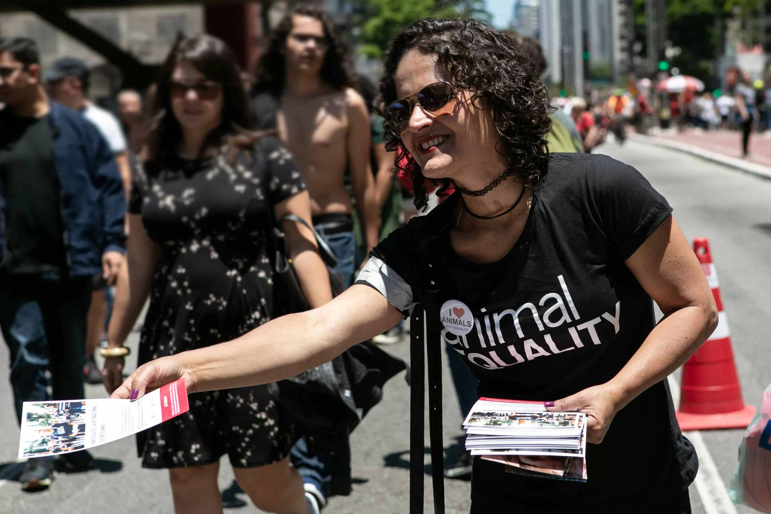 Voluntária distribui panfletos em ação de rua